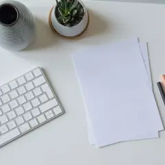 Schreibtisch mit Tastatur, Notizen, Stiften und Handy. Perfekt, um das Fernstudium zu organisieren und den Überblick zu behalten.
