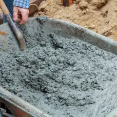Mieszanie betonu B20 w taczce. Właściwe proporcje składników są kluczowe dla uzyskania wytrzymałego materiału budowlanego.