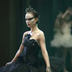 Natalie Portman jako Czarny Łabędź w koronie i czarnej tutu, z innymi tancerkami w tle.