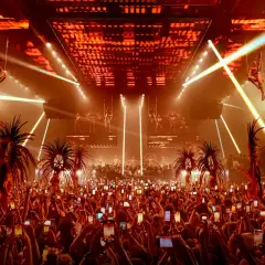 Folla festante con smartphone alzati per catturare lo spettacolo aereo e le performance, un'anticipazione dell'apertura discoteche Ibiza.