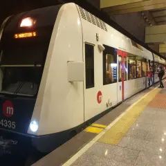 Nowoczesny pociąg metra w Walencji, numer 4335, stoi na peronie. Ludzie czekają na wejście.