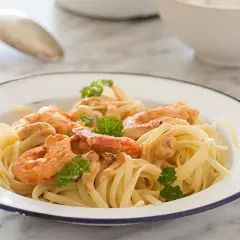 Pasta con jugosa salsa de langostinos, coronada con perejil fresco. Un plato delicioso y fácil de preparar.