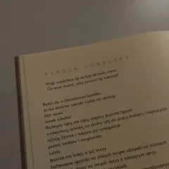 Otwarta książka z tekstem wiersza "Elegia Lubelska" Julii Hartwig.