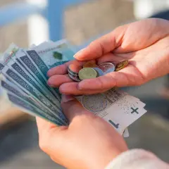 Dłonie liczą banknoty i monety. Czy to wystarczy na życie, gdy placa minimalna netto 2026 będzie obowiązywać?
