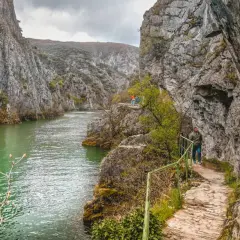 Vandra längs stigen i Matka Canyon, med turkost vatten och dramatiska klippor.
