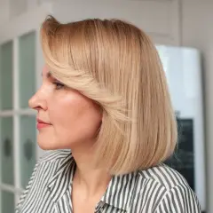 Kobieta z blond włosami w stylu french bob, w paski.
