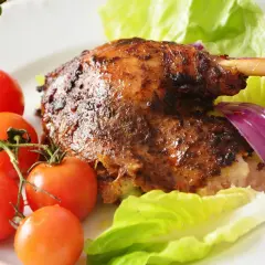 Pieczona kaczka z jabłkami, pomidorkami, pomarańczą i sałatą.