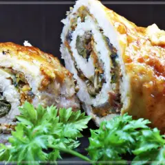 Roladki schabowe pieczone w naczyniu, z widocznym nadzieniem z warzyw i suszonych pomidorów, ozdobione natką pietruszki.