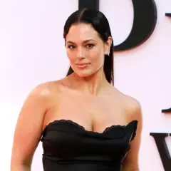 Ashley Graham posa con un vestido negro sin tirantes, luciendo elegante y segura.