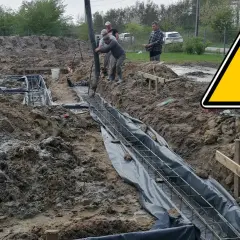 Budowa fundamentów: wylewanie betonu do zbrojenia w wykopie.