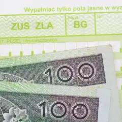 Zwolnienie lekarskie ZUS ZLA z polami na PESEL i kodami cyfrowymi, obok banknoty 100 zł.