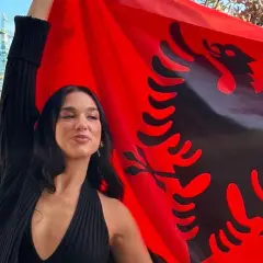 Dua Lipa z dumą prezentuje albańską flagę, podkreślając swoje dua lipa pochodzenie.