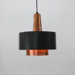 Stylowa lampa sufitowa z miedzi i czarnego metalu, dodająca ciepła wnętrzu.