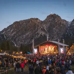 Tłumy ludzi na koncercie w Zakopanem pod oświetloną górą Giewont.