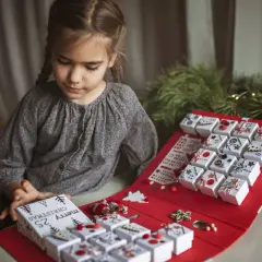 Niña prepara su calendario de adviento, una manualidad navideña para contar los días.