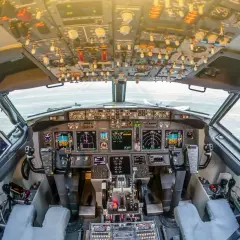 Kokpit samolotu a320neo. Widok z fotela pilota na zaawansowane przyrządy, ekrany i dźwignie sterowania.