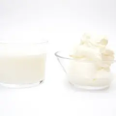 Un vaso de leche y un cuenco con crema de leche, mostrando la diferencia entre ambos.