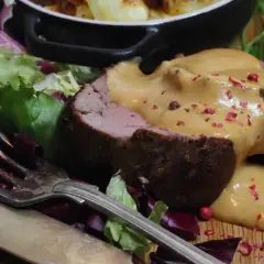 Saftig oxfilé med en krämig sås, garnerad med rosa pepparkorn. Serveras med sallad och potatis.