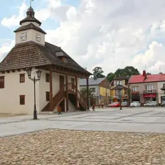 Rynek w Pilicy z ratuszem i studnią. Urokliwe miasto z brukowanym placem i kolorowymi kamienicami.
