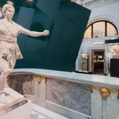 Antik staty i ett bra museum i Stockholm. Marmor och en grön vägg skapar en dramatisk bakgrund.