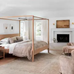 A cozy bedroom with a four-poster bed, fireplace, and plush seating, perfect for romance in bed.