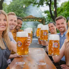 Freunde stoßen mit großen Krügen unfiltriertes Bier an.