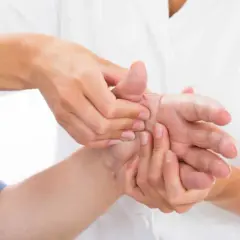 Mani che si massaggiano per alleviare il dolore al palmo della mano sotto il pollice.