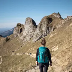 Wanderin auf einem Pfad in den beeindruckenden Berge in Bayern. Die Sonne scheint, der Himmel ist blau.