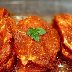 Karkówka z grilla w aromatycznej marynacie, ozdobiona listkami mięty. Gotowa do pieczenia.