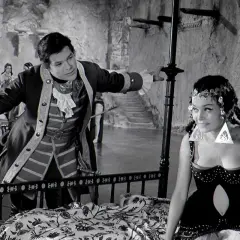 Mężczyzna w stroju z epoki i kobieta w orientalnym stroju na tle scenografii z filmu "Rękopis znaleziony w Saragossie".