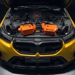 Żółte BMW M5 z otwartą maską, prezentujące dwa pomarańczowe intercoolery G-Power.