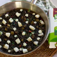 Arroz negro con sepia, adornado con trozos de sepia y puntos de alioli, listo para ser cocinado con arroz redondo Sabroz.