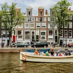 En båttur på kanalerna är ett måste i Amsterdam. Vackra hus och träd kantar vattnet.