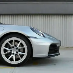 Srebrny Porsche 911 Carrera 4S z felgami i zaciskami hamulcowymi.