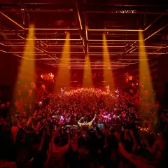 Folla in delirio per l'apertura discoteche Ibiza. Luci arancioni e DJ set infuocano la pista.