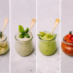 Vier Gläser mit selbstgemachtem Brotaufstrich: cremig-hell mit Dill, grün mit Basilikum, Avocado-grün und rot mit Tomaten.