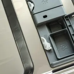 Wnętrze zmywarki Whirlpool po czyszczeniu. Widoczny dozownik na detergenty i nabłyszczacz, gotowy do kolejnego cyklu.