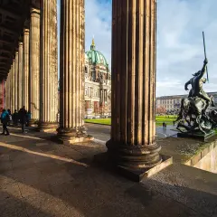 Niesamowite kolumny i rzeźba przed nowym muzeum w Berlinie. W tle widoczna kopuła katedry.