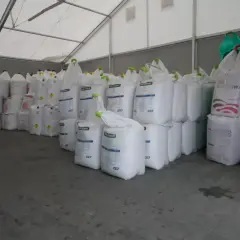Duże worki z nawozami, w tym lubofoska pod zboża, czekają na rozładunek w magazynie.
