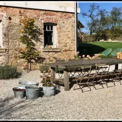 Rusty metal chairs await guests at a rustic table, perfect for enjoying the autumn charm of agroturystyka Dolny Śląsk.