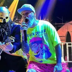 Limp Bizkit Polska na koncercie. Wokalista w neonowej koszulce i gitarzysta w masce.