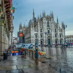 Katedra Duomo w Mediolanie i plac przed nią w deszczowy dzień.