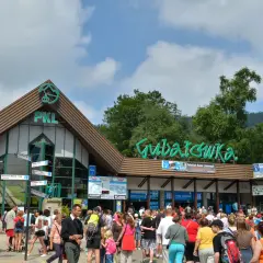 Tłum ludzi czeka na wjazd na Gubałówkę. W tle budynek PKL i zielony napis "Gubałówka".