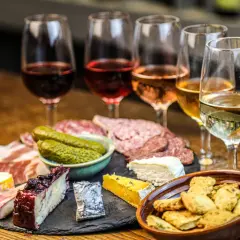 Calici di vini naturali a Firenze, accompagnati da salumi, formaggi e sottaceti. Un'esperienza gustosa.