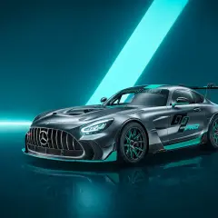 Szary Mercedes-AMG GTR Pro z turkusowymi akcentami i dużym skrzydłem, gotowy do wyścigu.