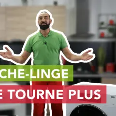 Un homme explique pourquoi son sèche-linge ne tourne plus, devant un appareil et une cuisine floue.