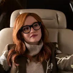 Anna Delvey, grana przez Julię Garner, w luksusowym wnętrzu samolotu, robiąc selfie.