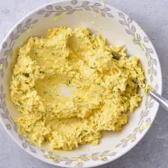 Mieszanka jajeczna z ziołami, przygotowana jako pasta jajeczna bez majonezu, w misce z ozdobnym brzegiem.