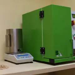 Sprzęt laboratoryjny do analizy pelletu, w tym waga i urządzenie Tumbler 1000, pomagają ustalić, jak sprawdzić kaloryczność pelletu.