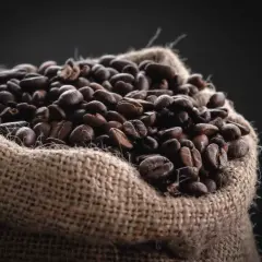 Un saco de arpillera lleno de granos de café tostados, una fuente natural de cafeína para el pelo.